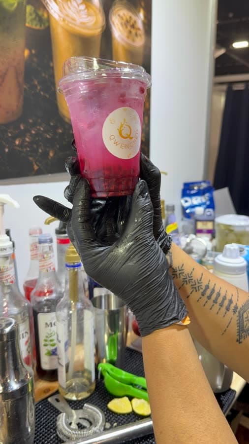 A guest holding a Qwenched signature drink